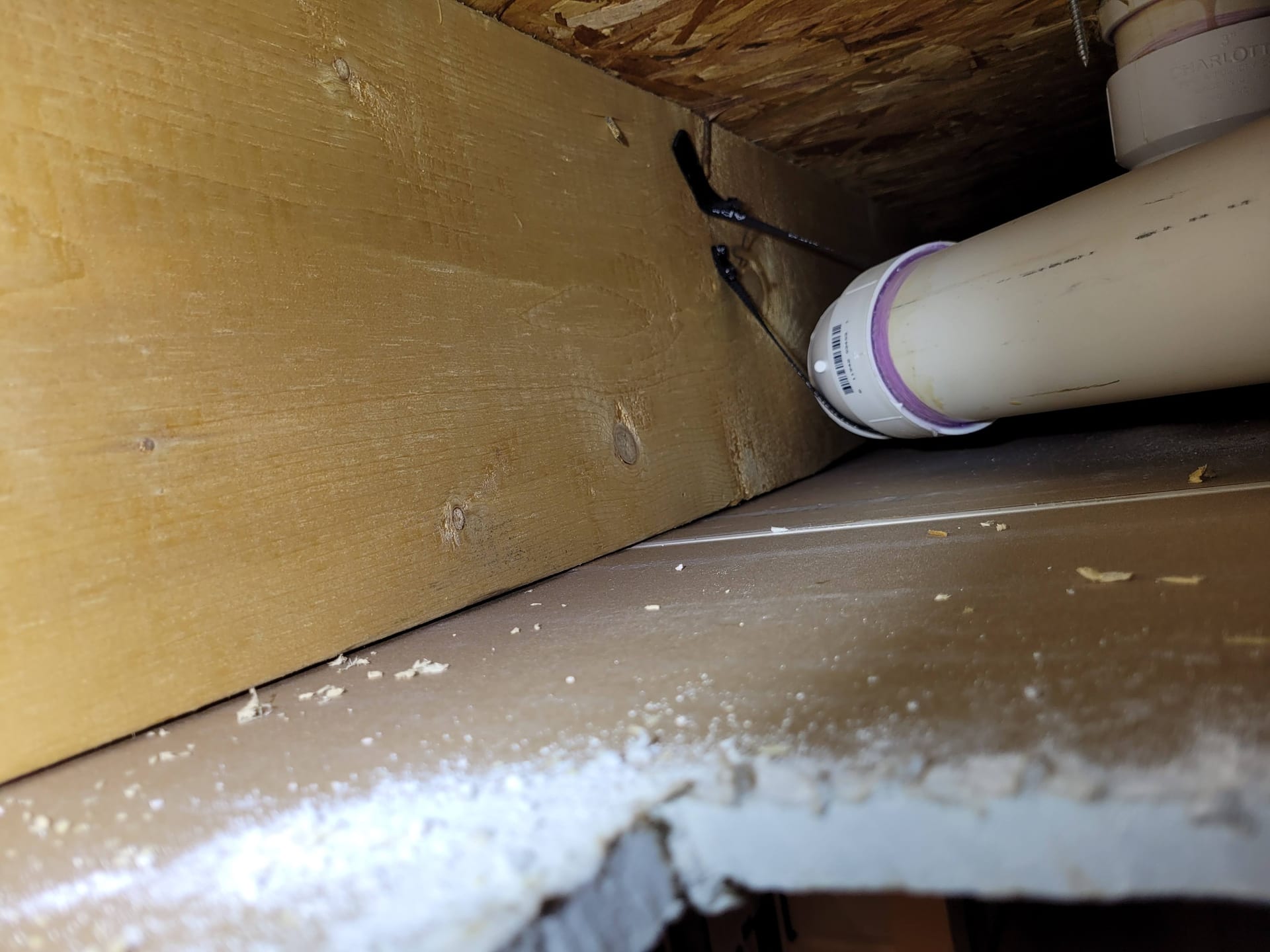 Inspecting ceiling drywall framing and PVC piping