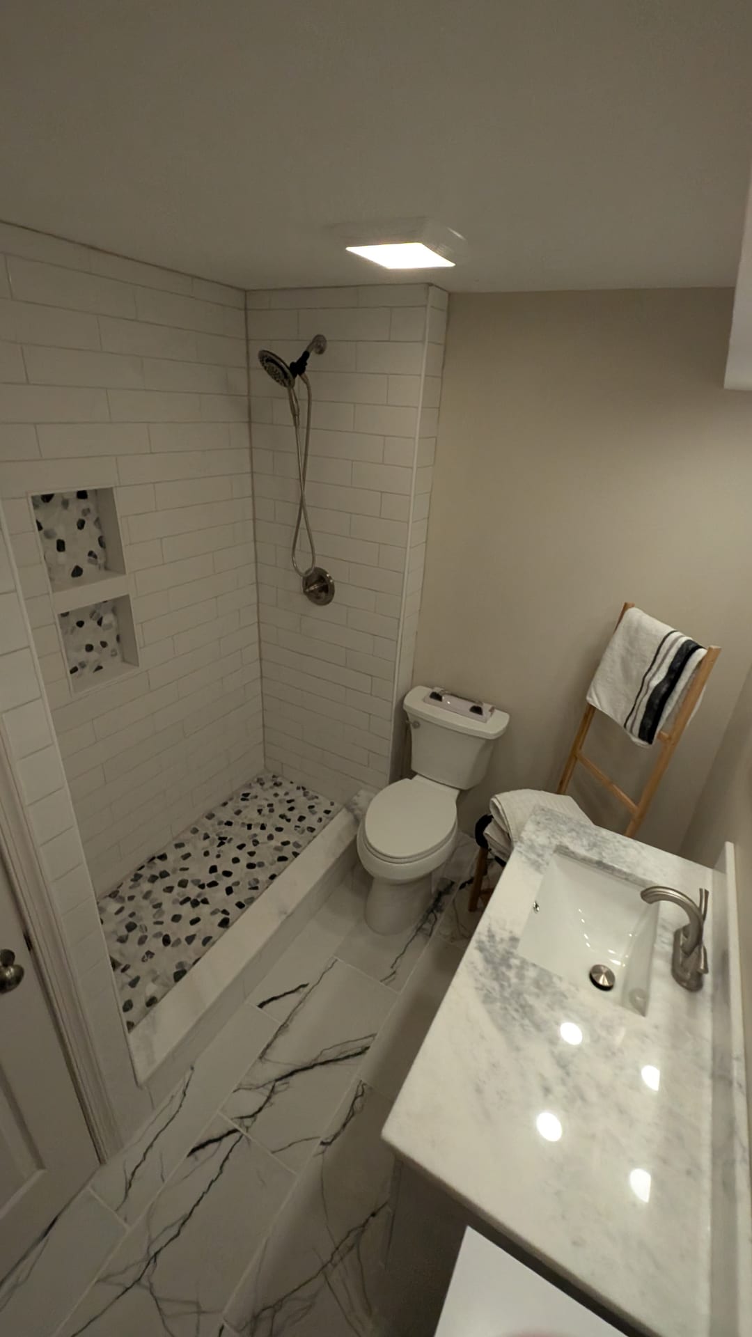 Custom restored basement bathroom with tiled shower enclosure
