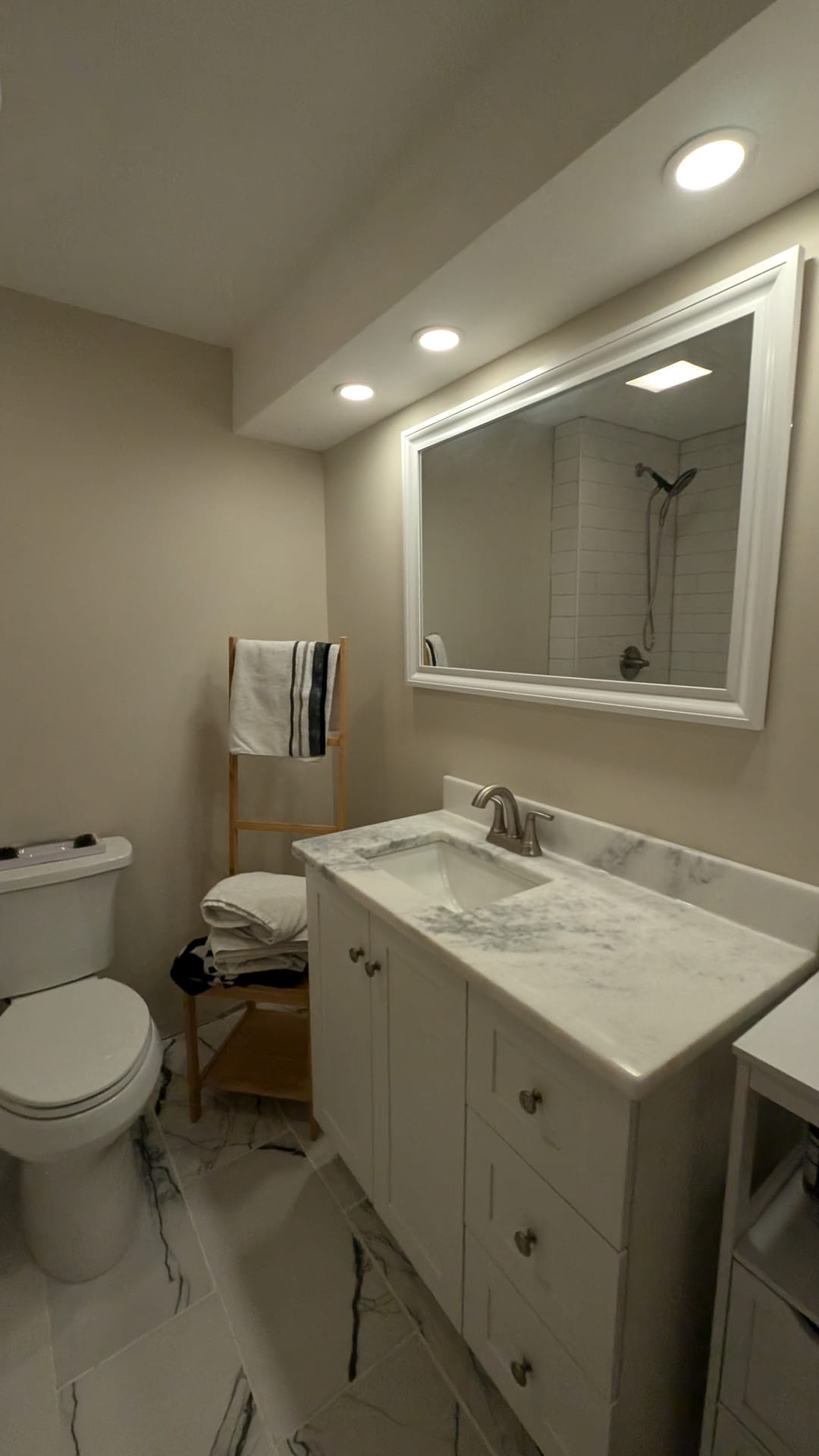 Finished custom basement bathroom vanity with backlit mirror