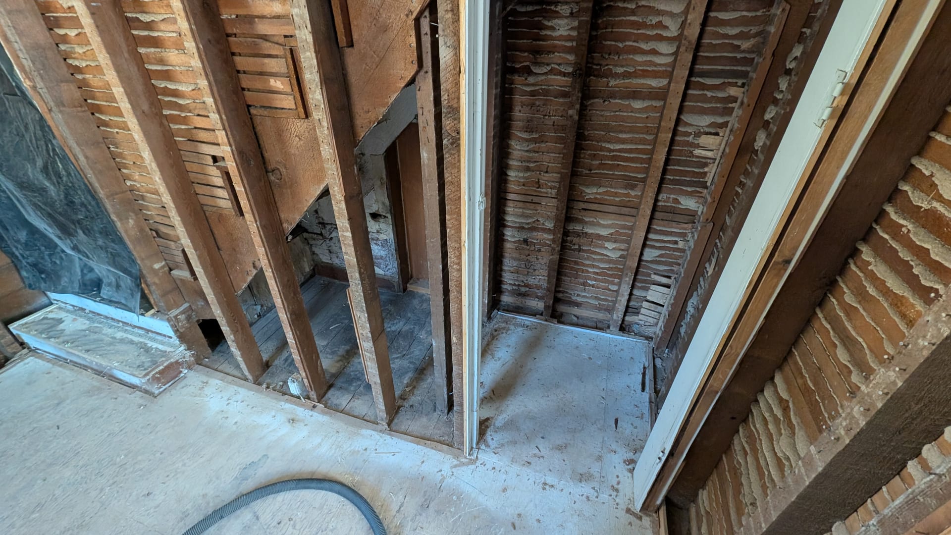 Exposed stairwell studs and lath work during rebuild